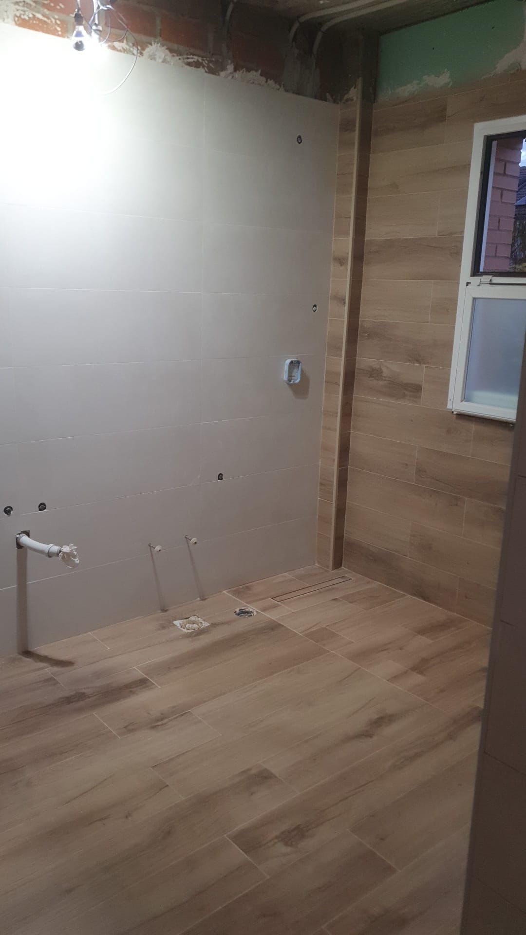 Acabado final de una ducha revestida con cerámica efecto madera