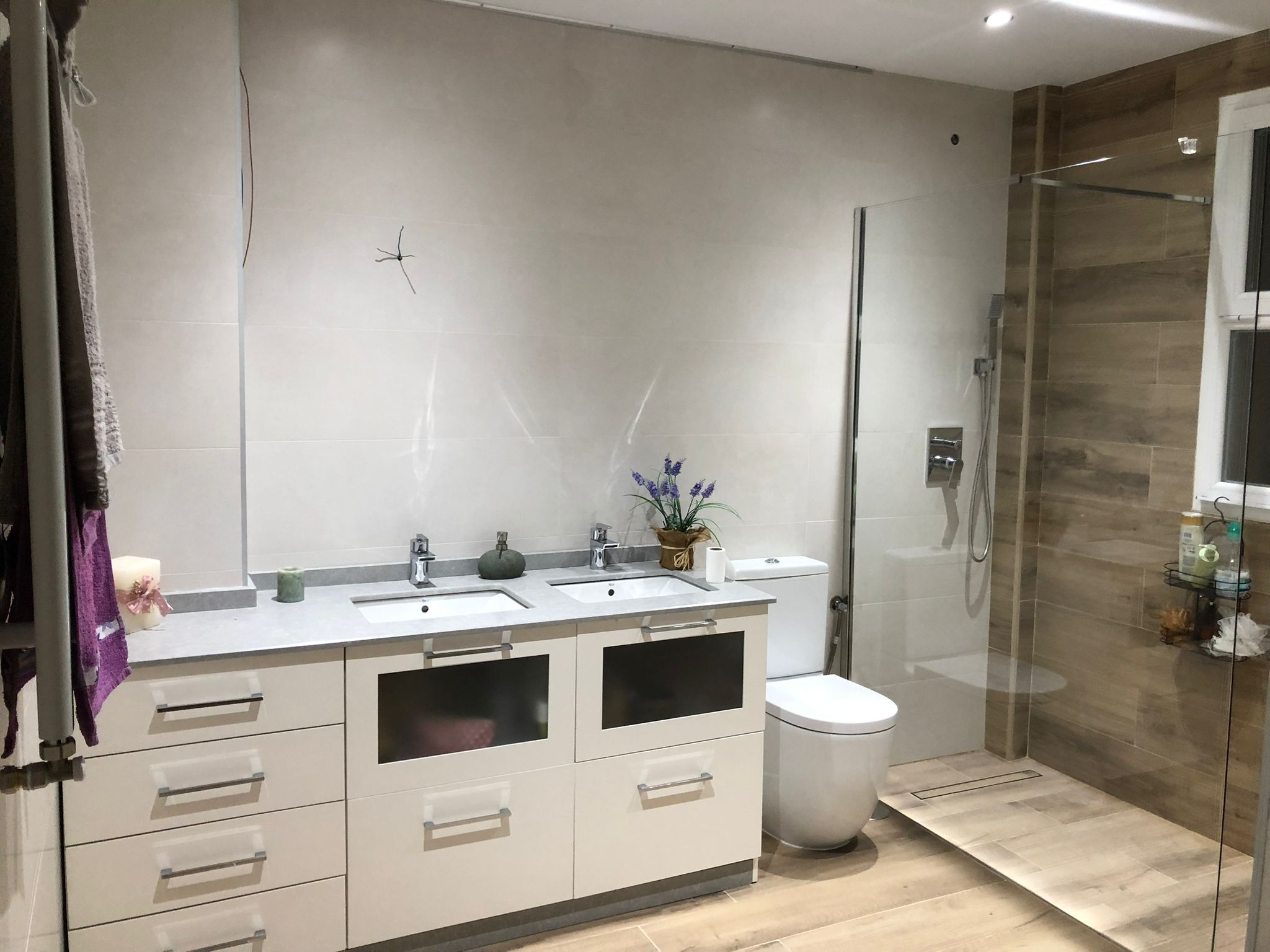 Baño reformado con mueble de doble lavabo y ducha de cristal